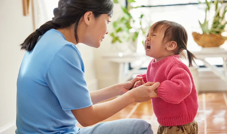 Mother talking to a toddler throwing tantrums