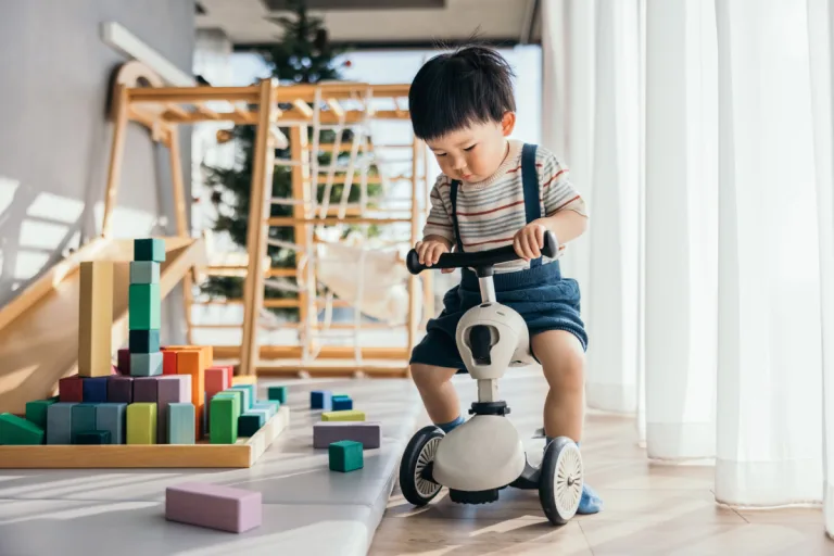 A toddler playing on a bike
