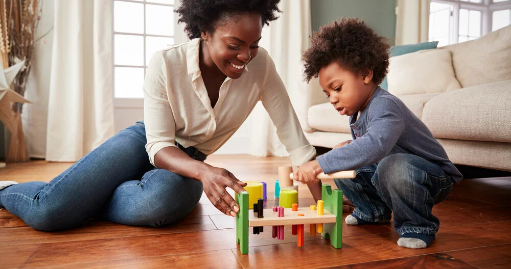 Mother and 2 year old toddler playing with toys