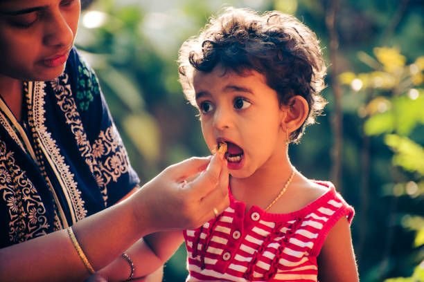 Toddler being fed by mother